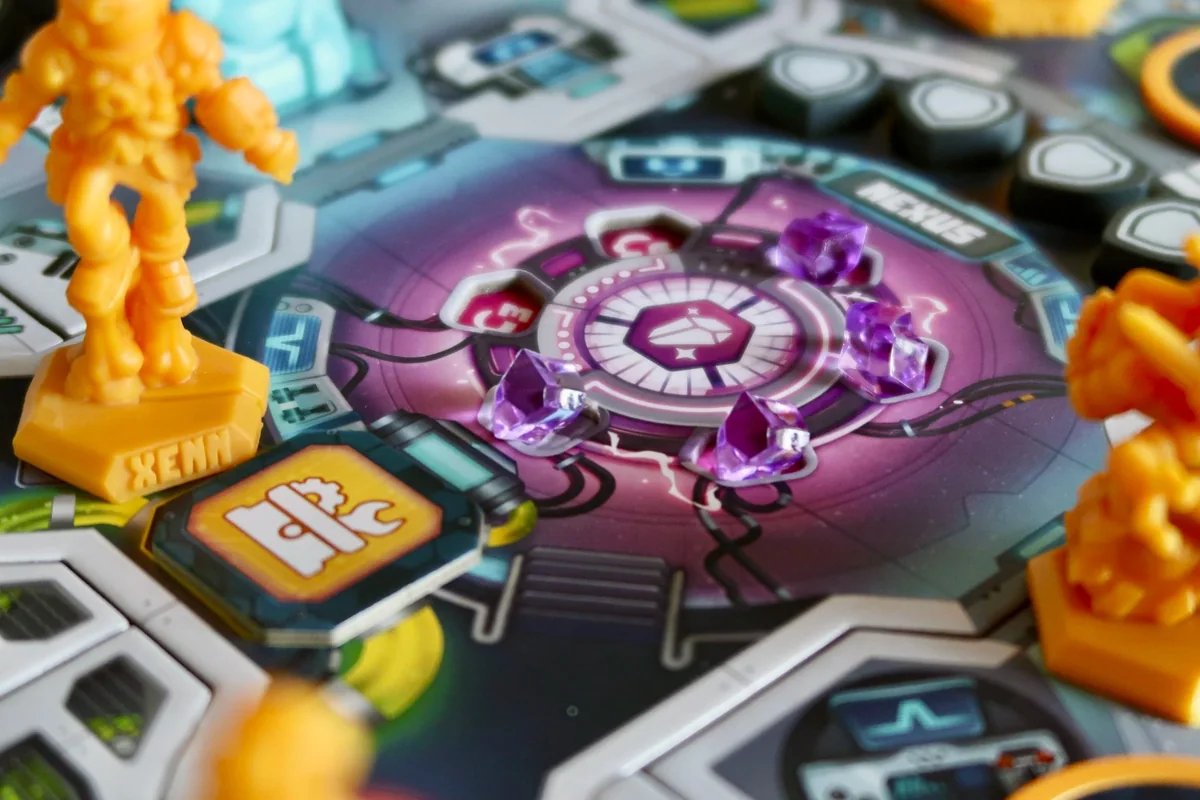 orange rider miniatures beside the purple crystals at the centre of a Spark Riders 3000 ship room.